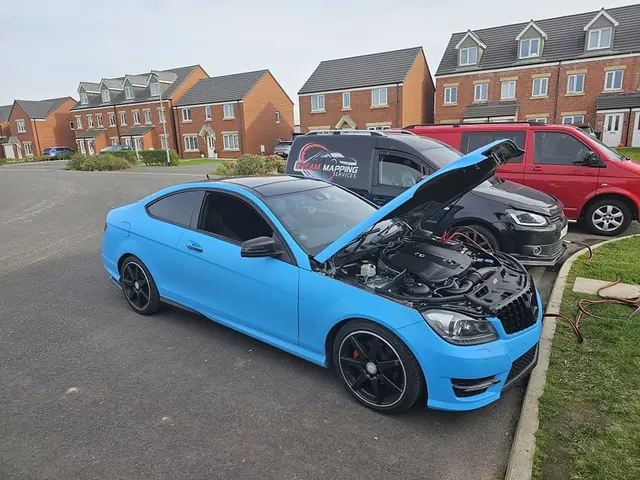 Blue Mercedes C250 coupé with the bonnet up beside the Dream Mapping van